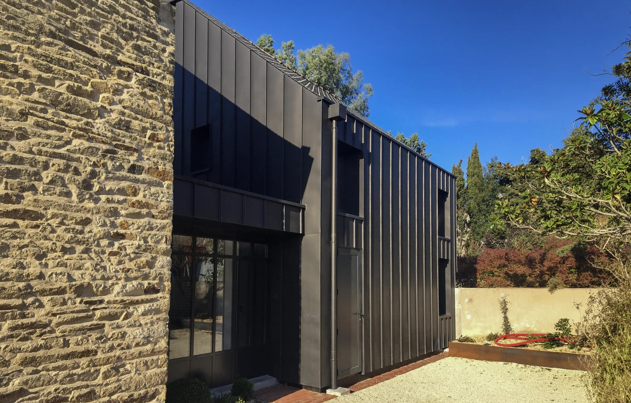 Toiture résidentielle en ardoise naturelle présentant une prolifération importante de mousse verte