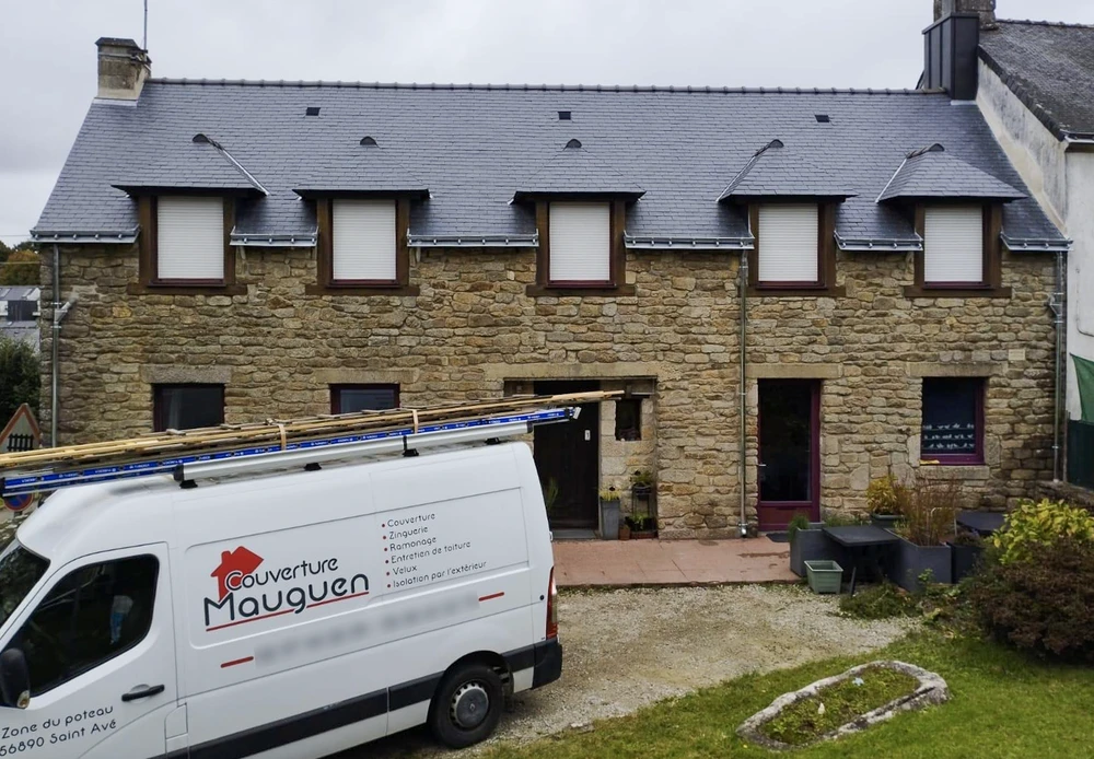 Homme en veste denim tenant un couteau de poche ouvert près de son visage, portant des gants tactiques noirs avec renforts