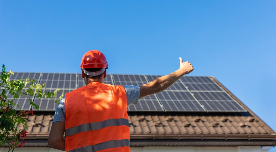 Chantier de réfection de toiture en cours, ouvriers installant une structure de ventilation ou cheminée sur toit résidentiel